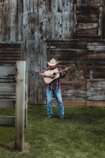 A lively radio DJ playing country music with a rustic farm backdrop.