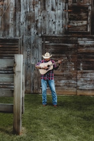 A lively radio DJ playing country music with a rustic farm backdrop.
