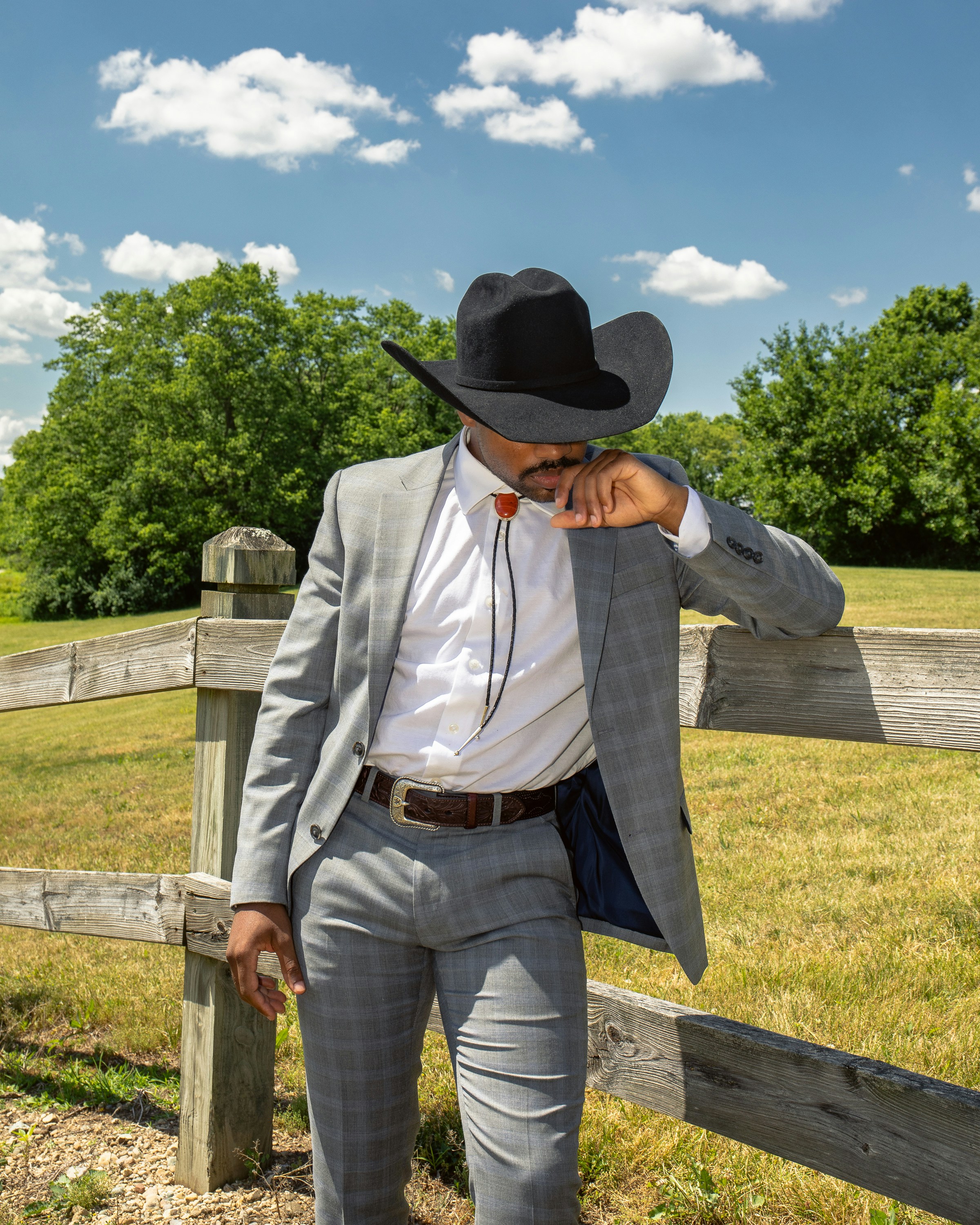 Man In White Dress Shirt And Blue Denim Jeans Wearing Black Cowboy Hat Standing On Brown Photo Free Clothing Image On Unsplash