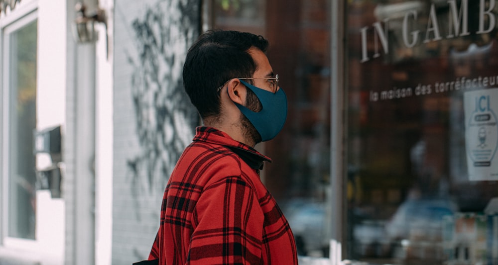 Hombre con camisa de vestir a cuadros rojos y negros con gafas azules