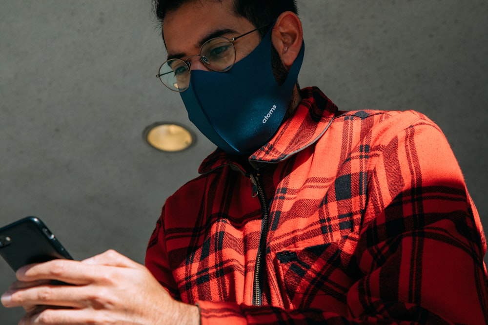 man in red and black plaid button up shirt wearing blue mask