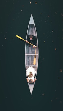 man in black shirt riding on brown boat