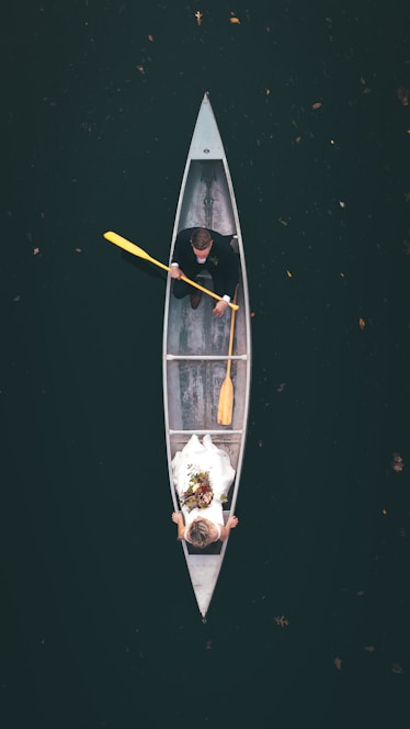 man in black shirt riding on brown boat