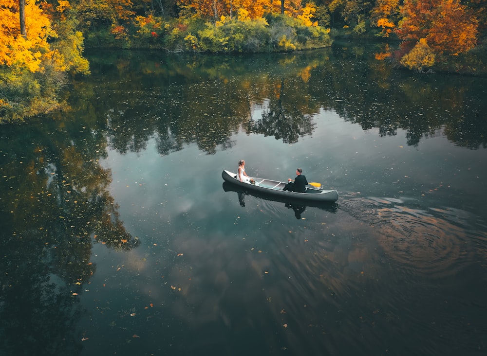 2 person riding on boat on lake during daytime