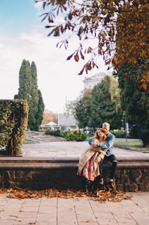 A cozy couple sitting together on a park bench during autumn.