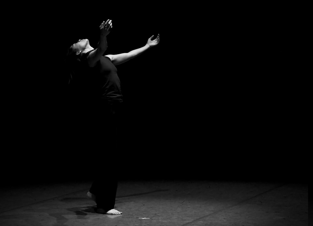 man in black t-shirt and black pants standing on black floor