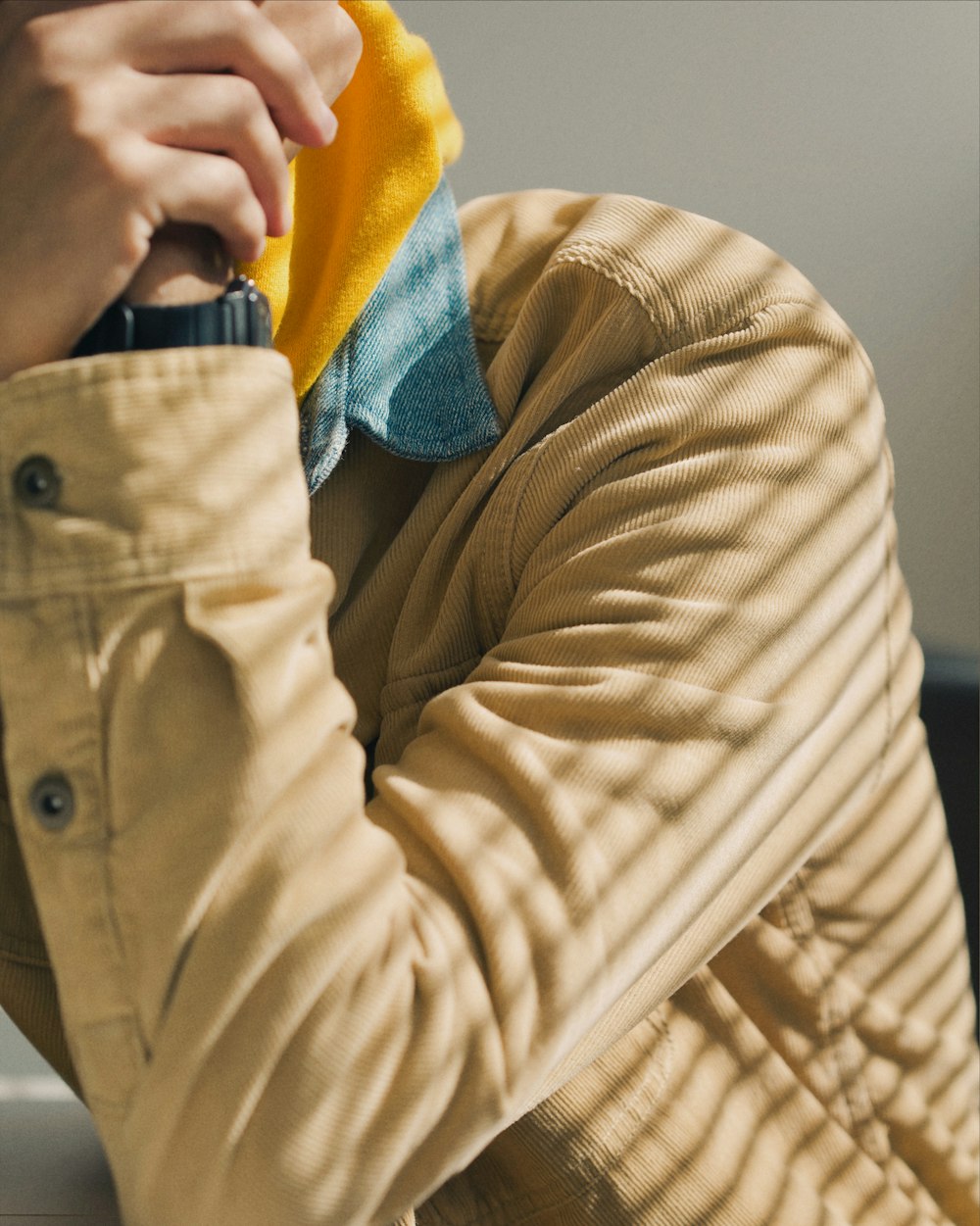 person in brown jacket wearing blue and yellow knit cap