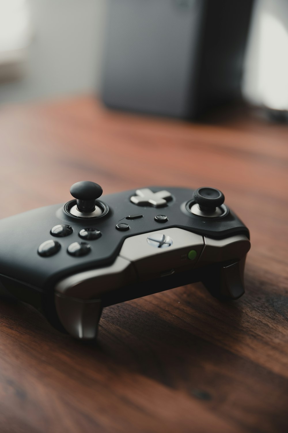 black xbox game controller on brown wooden table