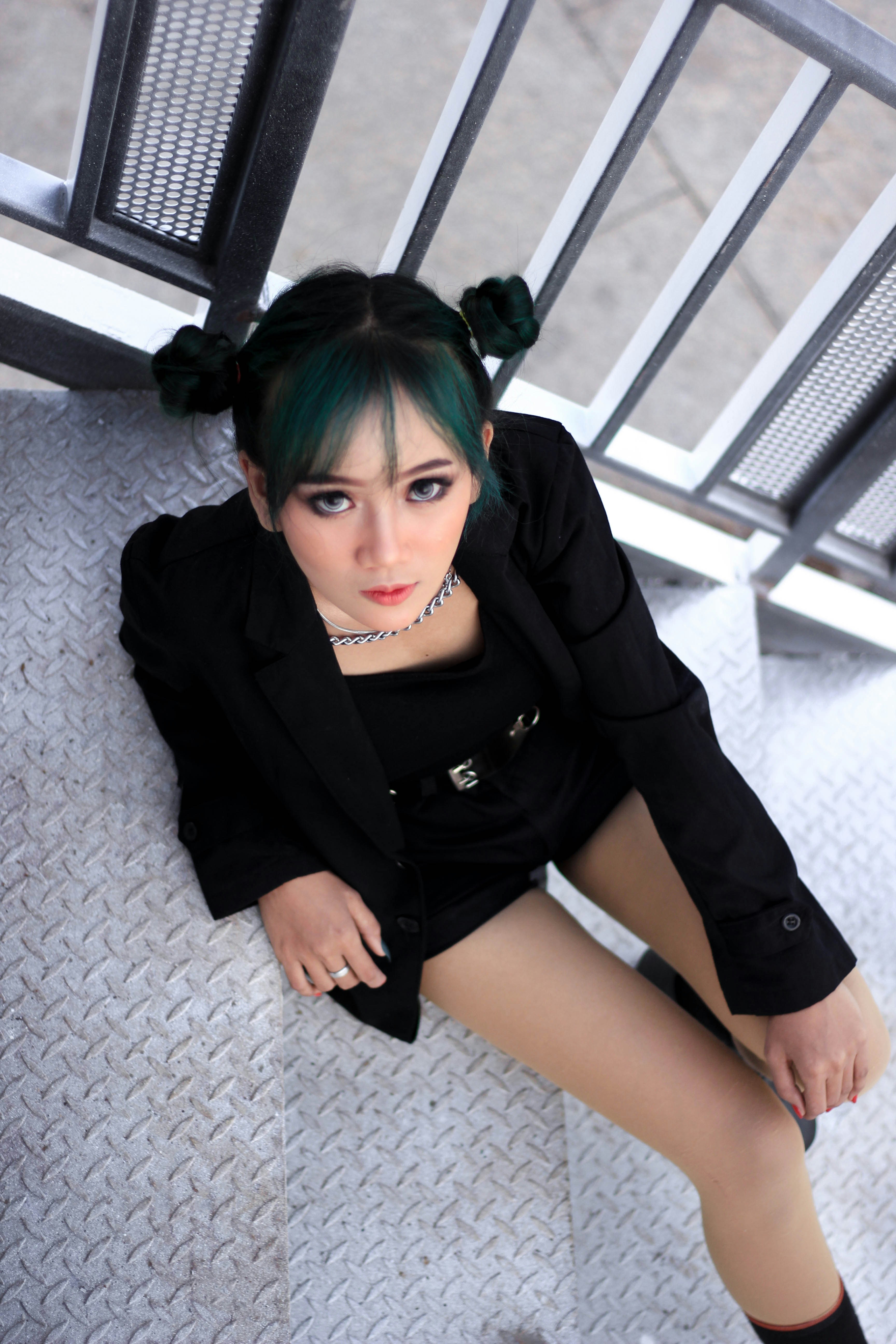 Wanita berbaju blazer hitam duduk di lantai