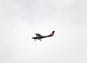 white and red airplane in mid air