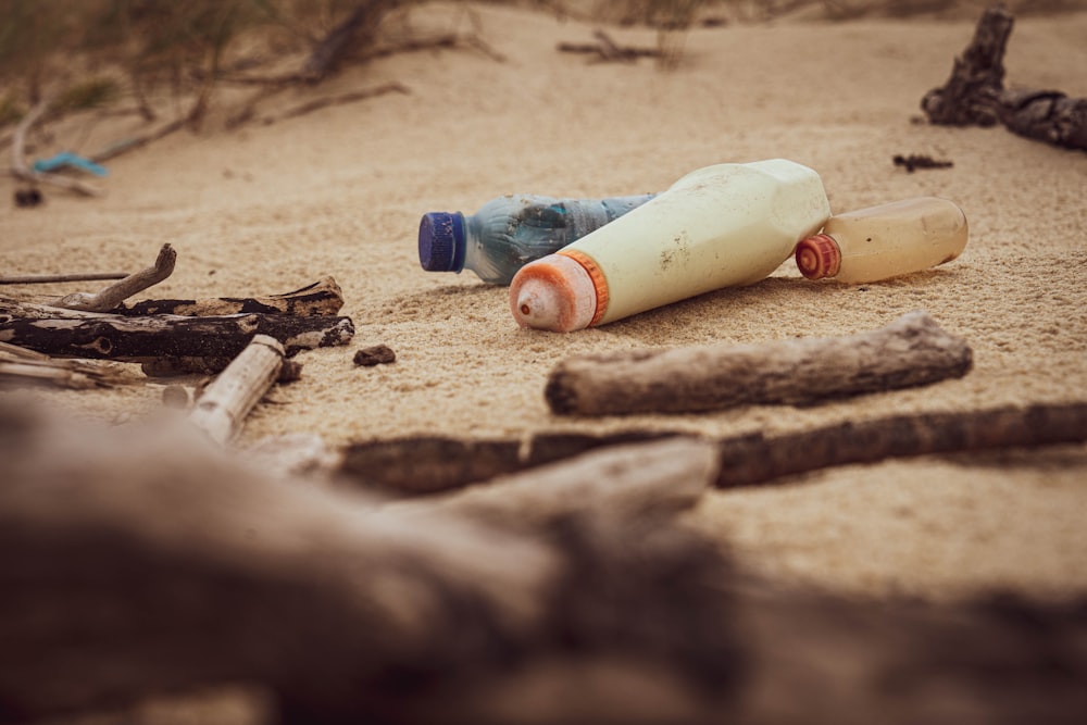Botella de plástico blanca y azul sobre arena marrón