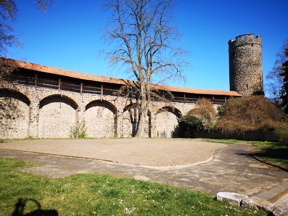 brown brick building near green grass field under blue sky during daytime