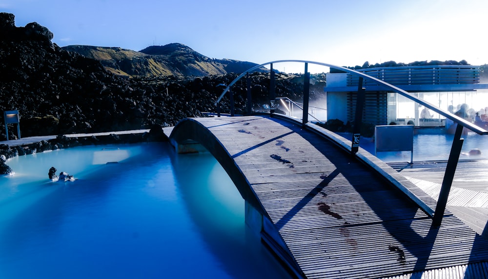 Piscine bleue et noire près du quai en bois brun pendant la journée