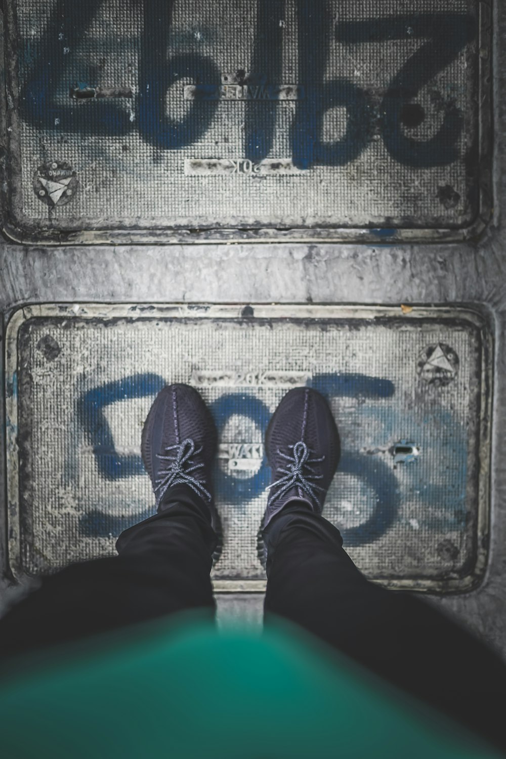 a person standing in front of a metal sign