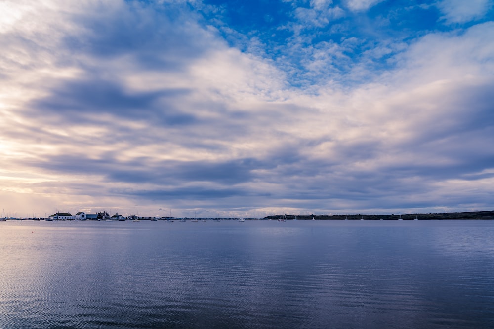 body of water under blue sky and white clouds during daytime