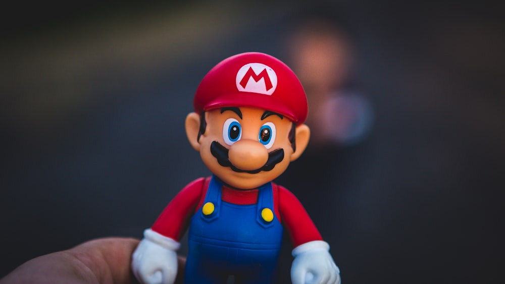 super mario na estatueta da camisa azul e vermelha