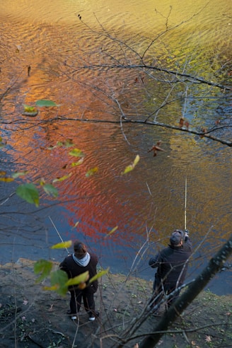 people fishing on river during daytime