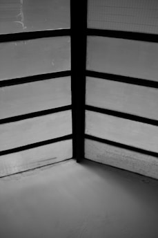 Black and white photograph of a serene, minimalist interior space featuring clean lines and natural light.