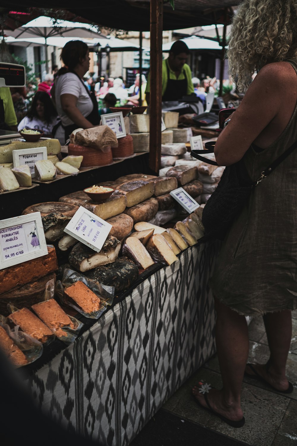 Uomo in maglietta nera e pantaloncini neri in piedi davanti all'espositore del pane