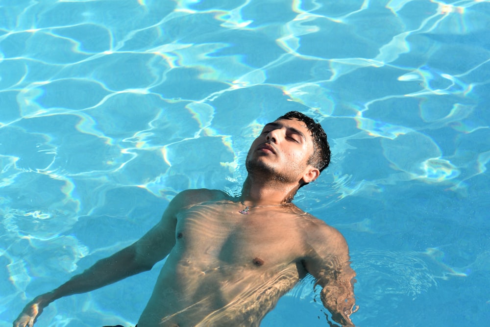 topless man in water during daytime