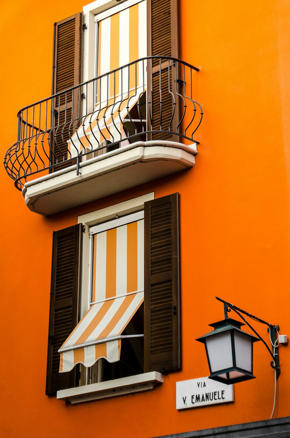 オレンジ色の塗装壁に黒い金属窓枠
