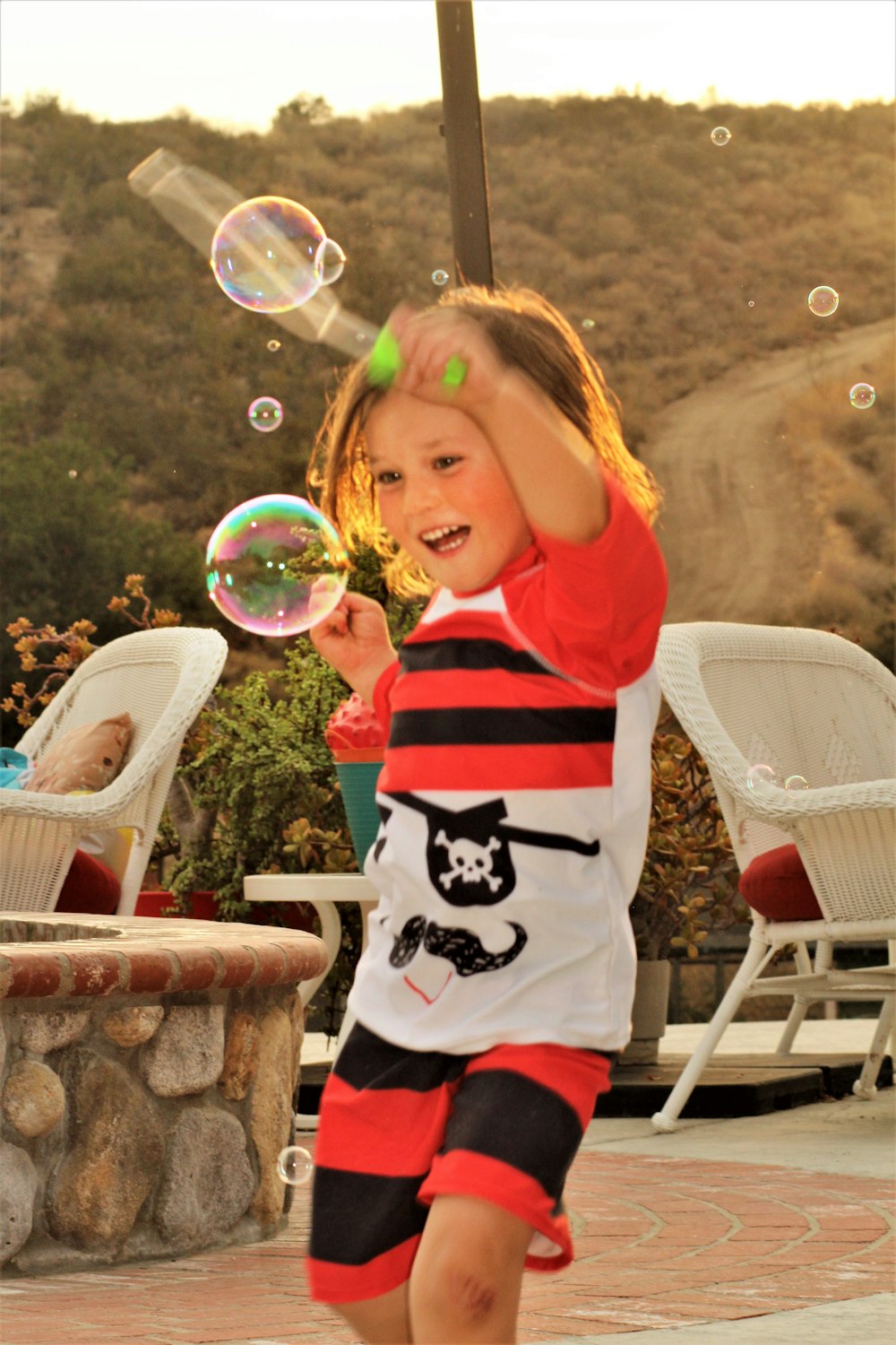 girl in red and white stripe shirt playing bubbles
