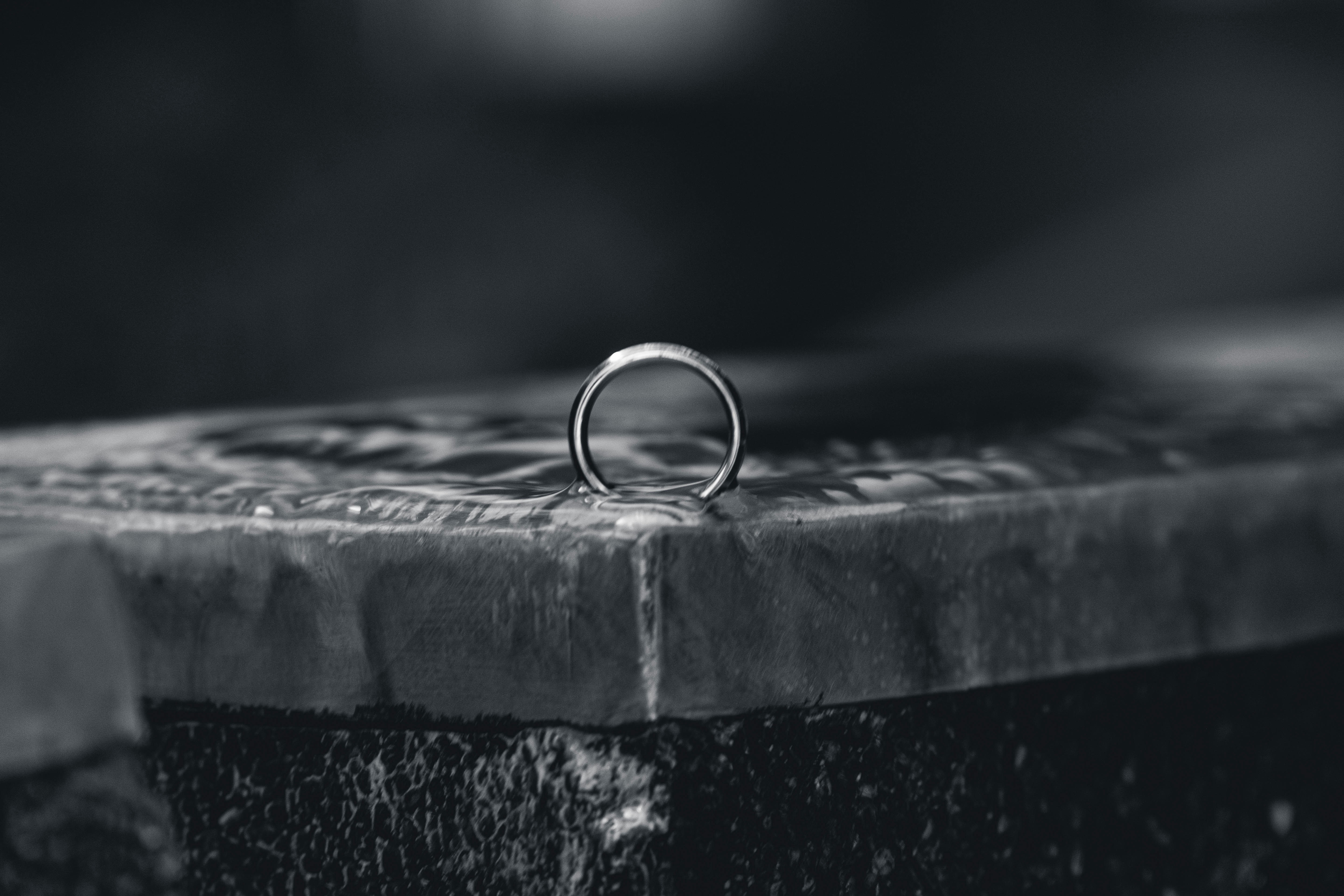 silver ring on black concrete surface