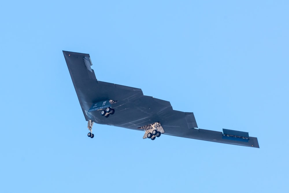black jet plane in mid air during daytime