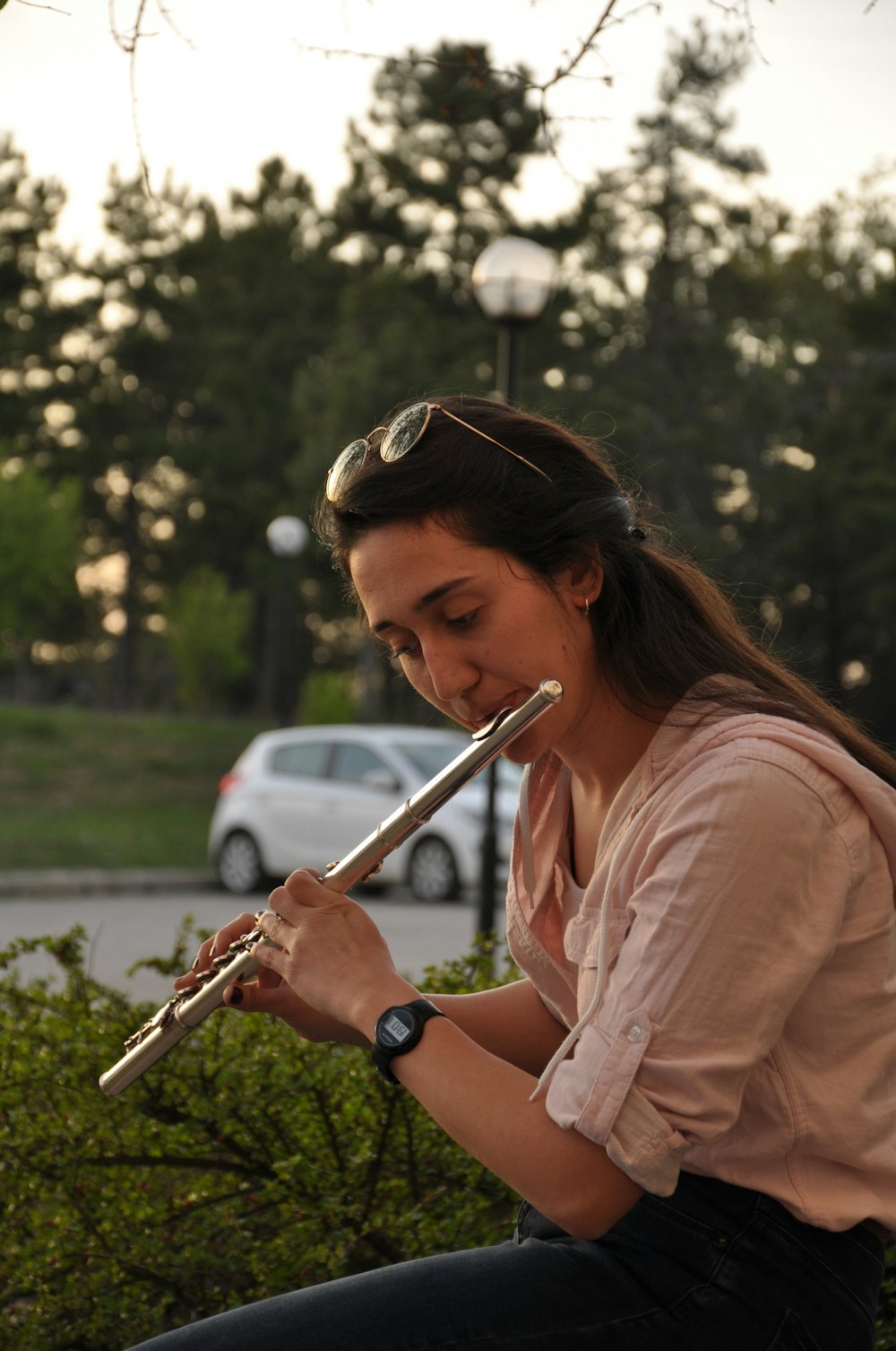 woman in pink dress shirt holding silver flute