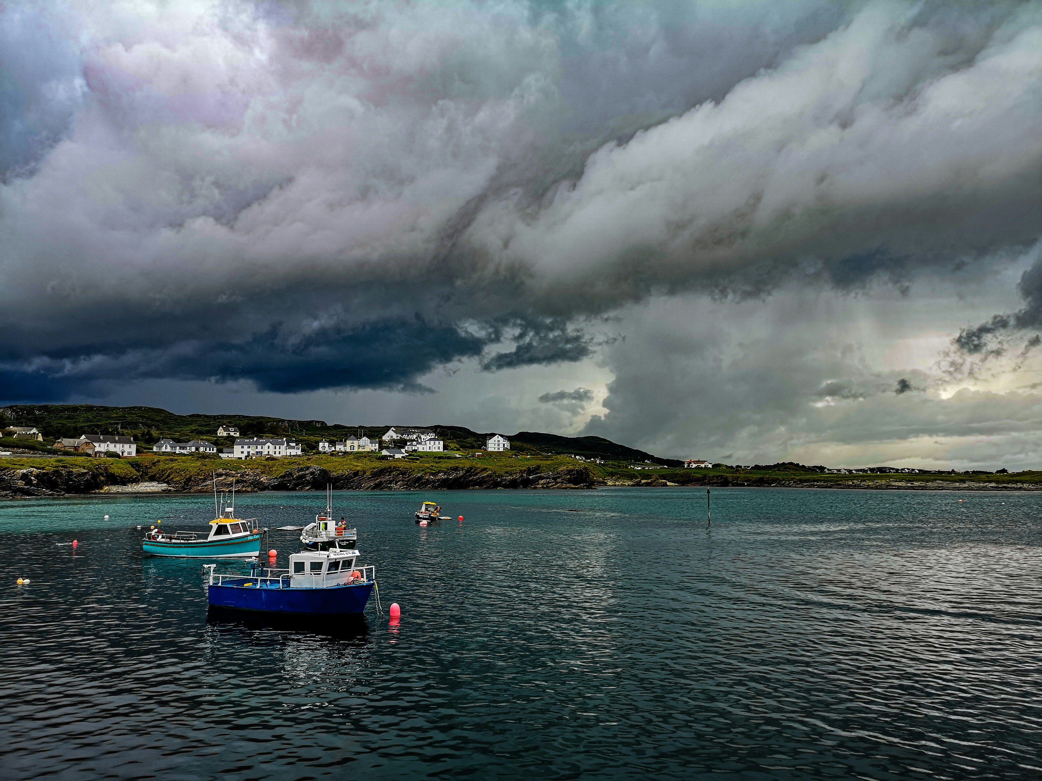 bateau blanc et bleu sur la mer sous ciel nuageux pendant la journée