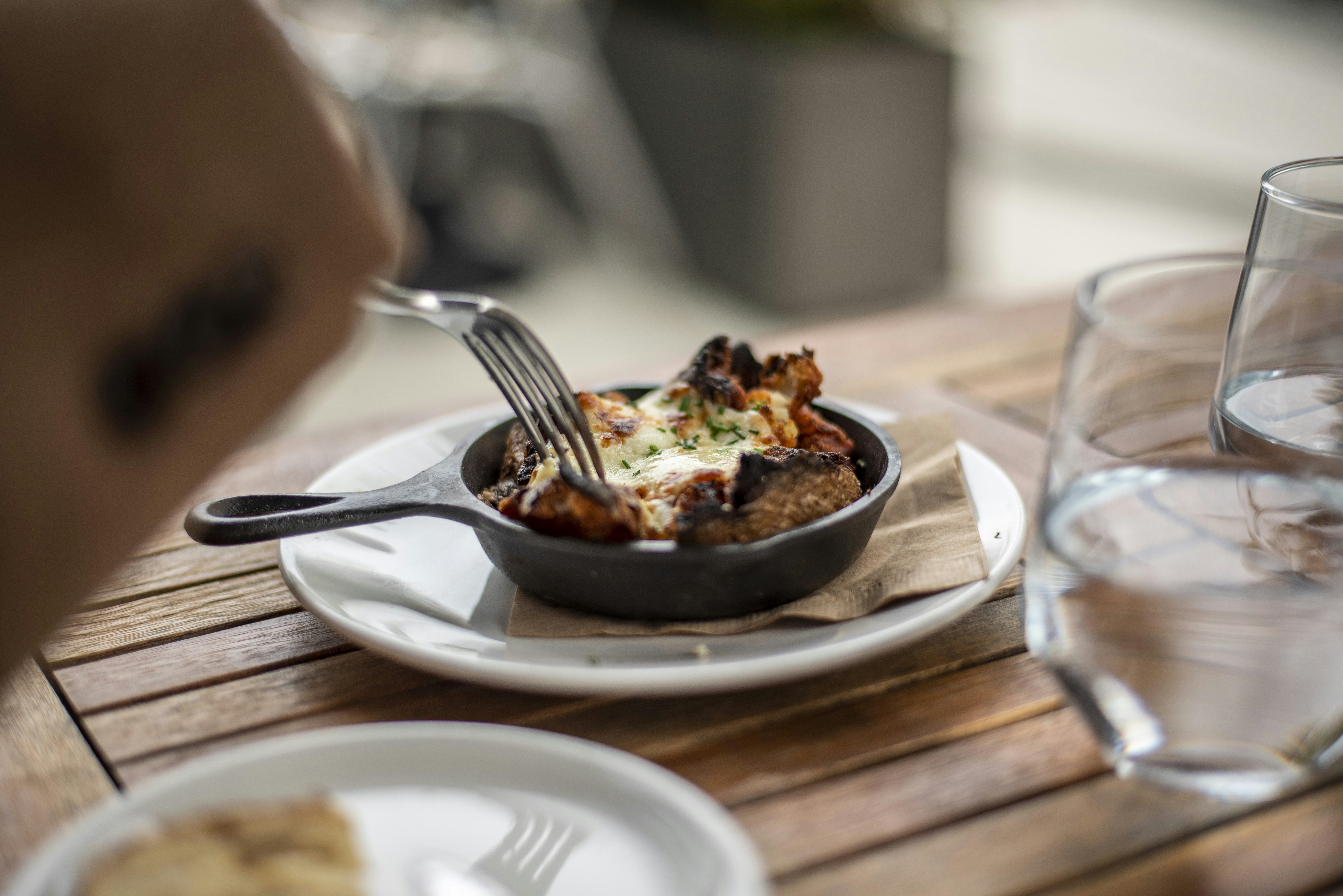 Potato with topped Mozzarella cheese cooked in a casted iron pot.