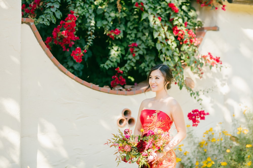 woman in pink and white floral tube dress holding bouquet of flowers