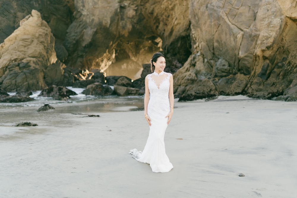 woman in white dress standing on white sand beach during daytime