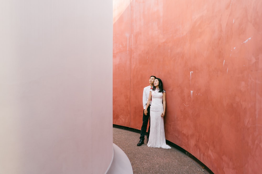 man and woman standing beside brown wooden door