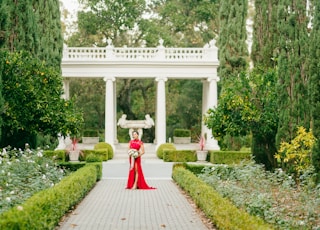 woman in red dress walking on pathway during daytime