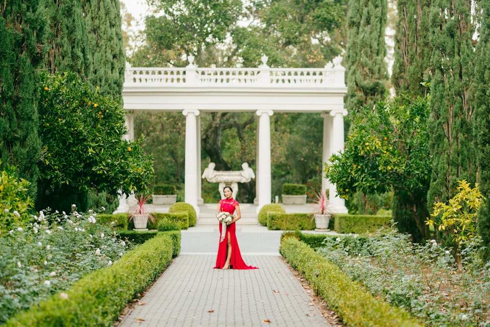 woman in red dress walking on pathway during daytime