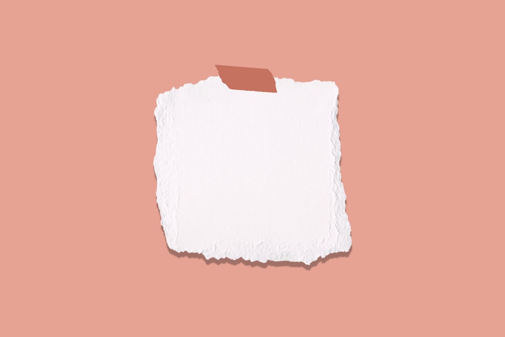 weißes und blaues Papier auf rosa Oberfläche
