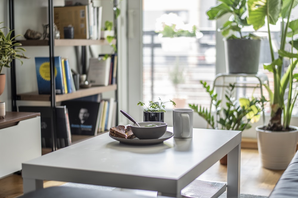 Mesa de madera marrón con cuenco de cerámica blanca y platillo