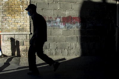 A shadowy figure in an oversized streetwear jacket walking through dimly lit alleyways, embodying rebellion.