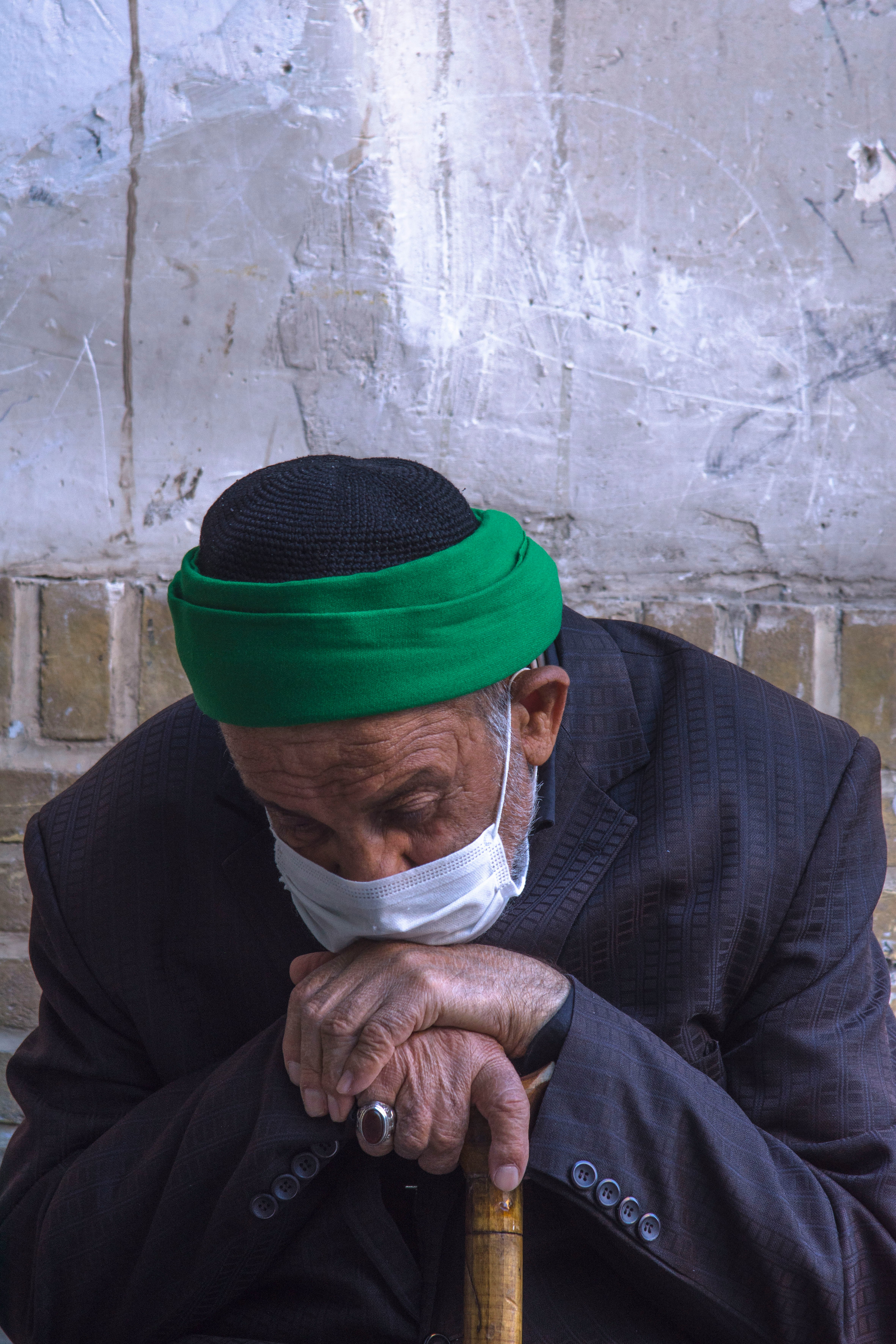 man in black suit jacket wearing green cap