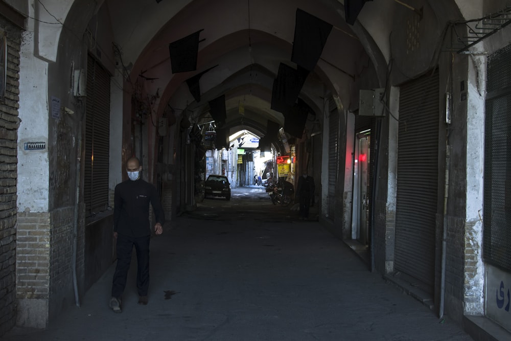 man in black jacket walking on hallway