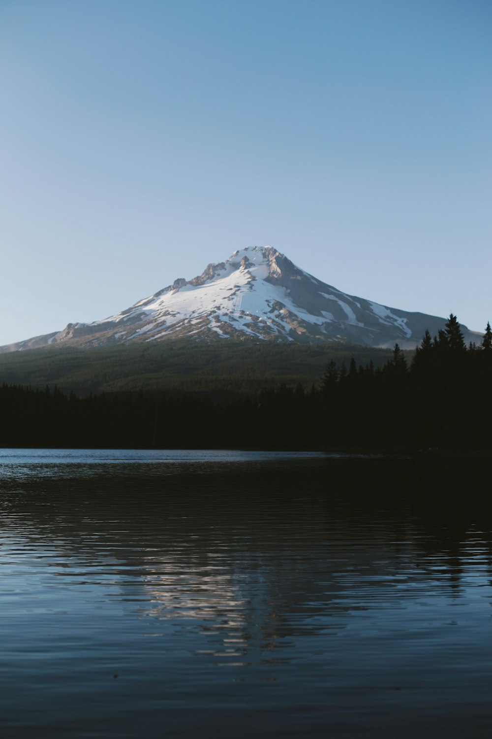 body of water near mountain during daytime