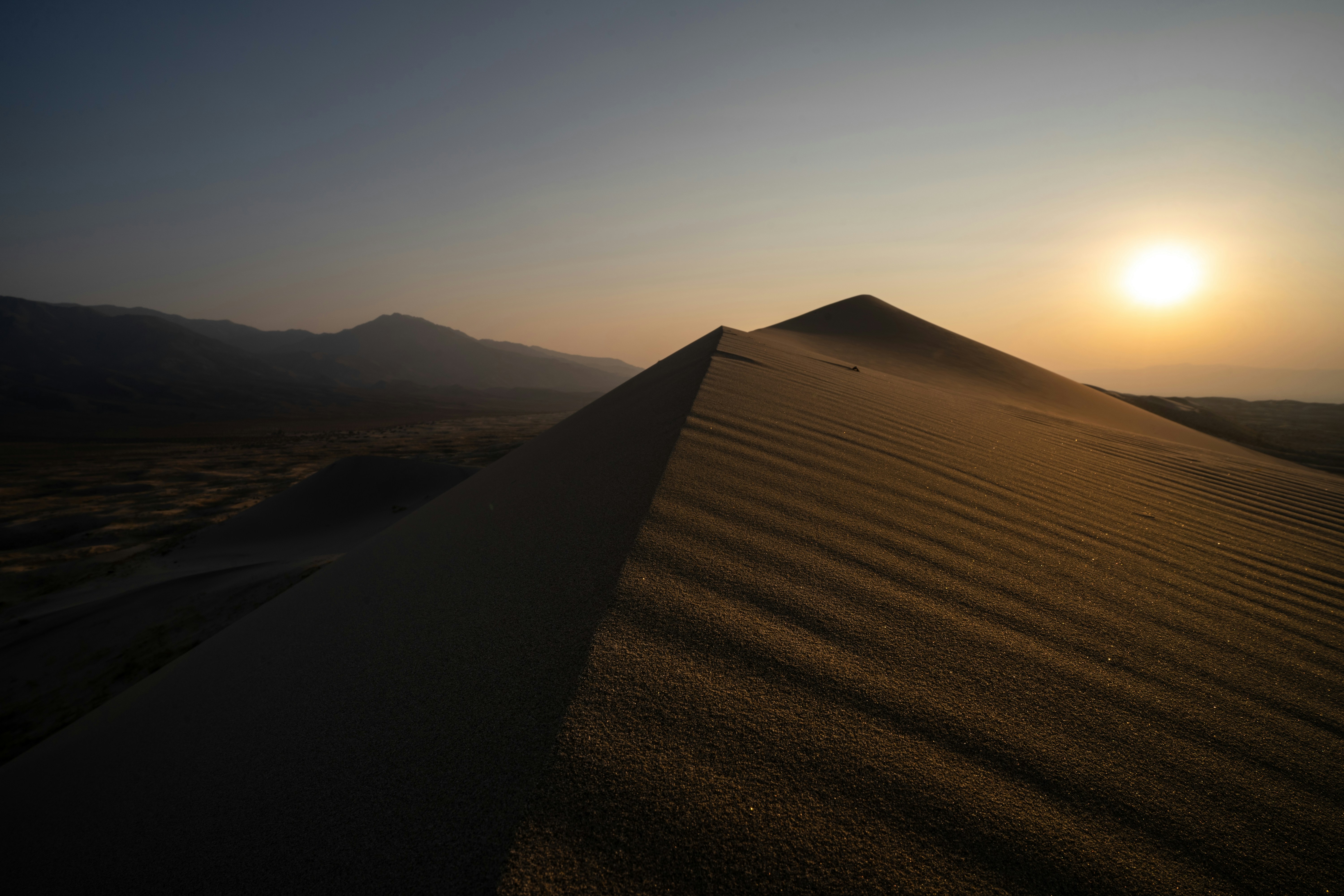 brown sand field during sunset, The sun begins to set over smoky Mojave