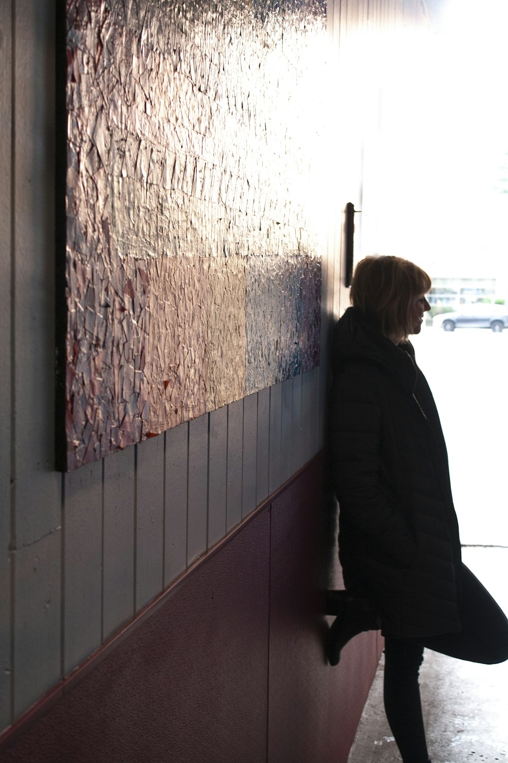woman in black jacket standing near window