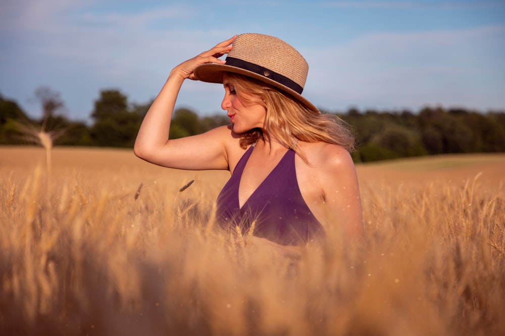 woman in black tank top wearing brown straw hat standing on brown field during daytime