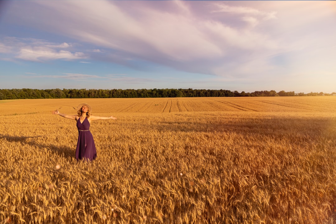 woman in black dress standing on brown grass field during daytime