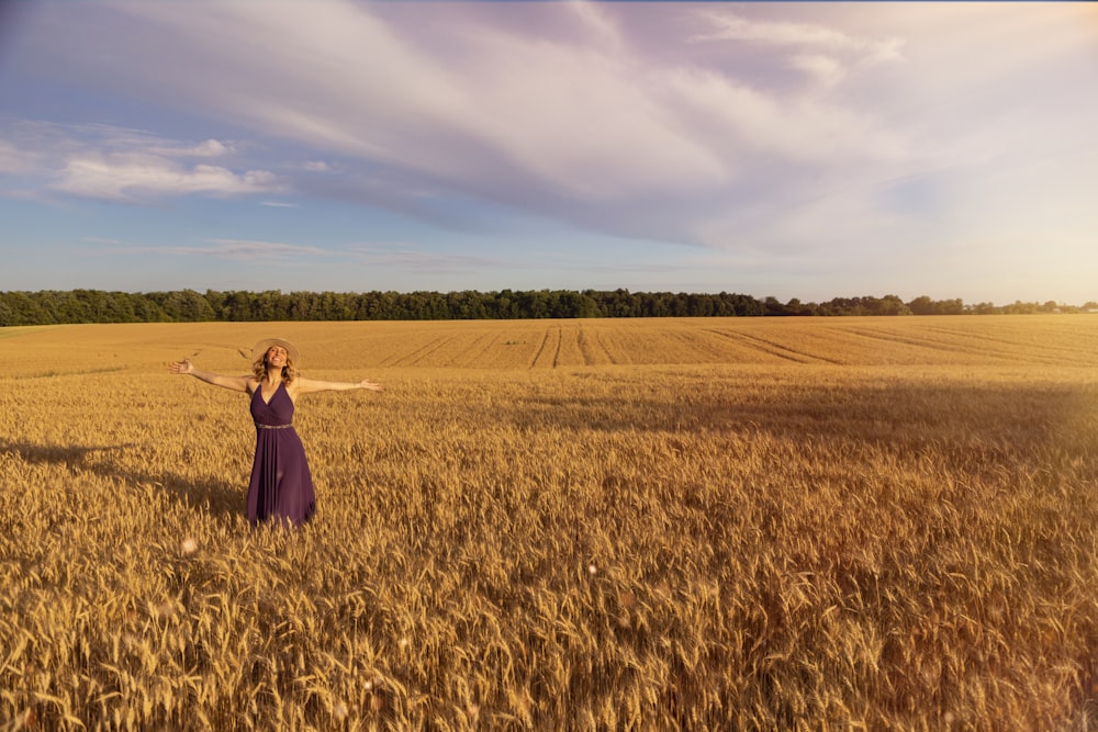 woman in black dress standing on brown grass field during daytime