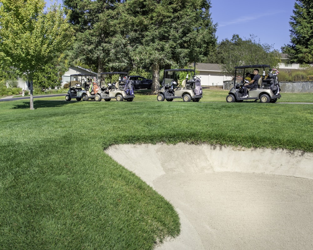 people riding golf cart on green grass field during daytime