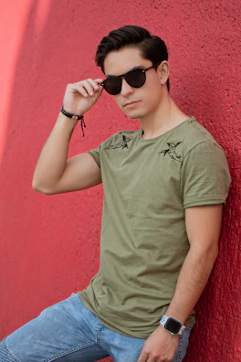Editorial shot of a man adjusting his terravibe watch while leaning on a concrete wall.