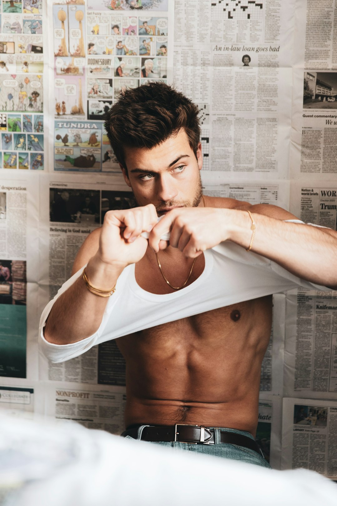 man in white tank top covering face with white towel